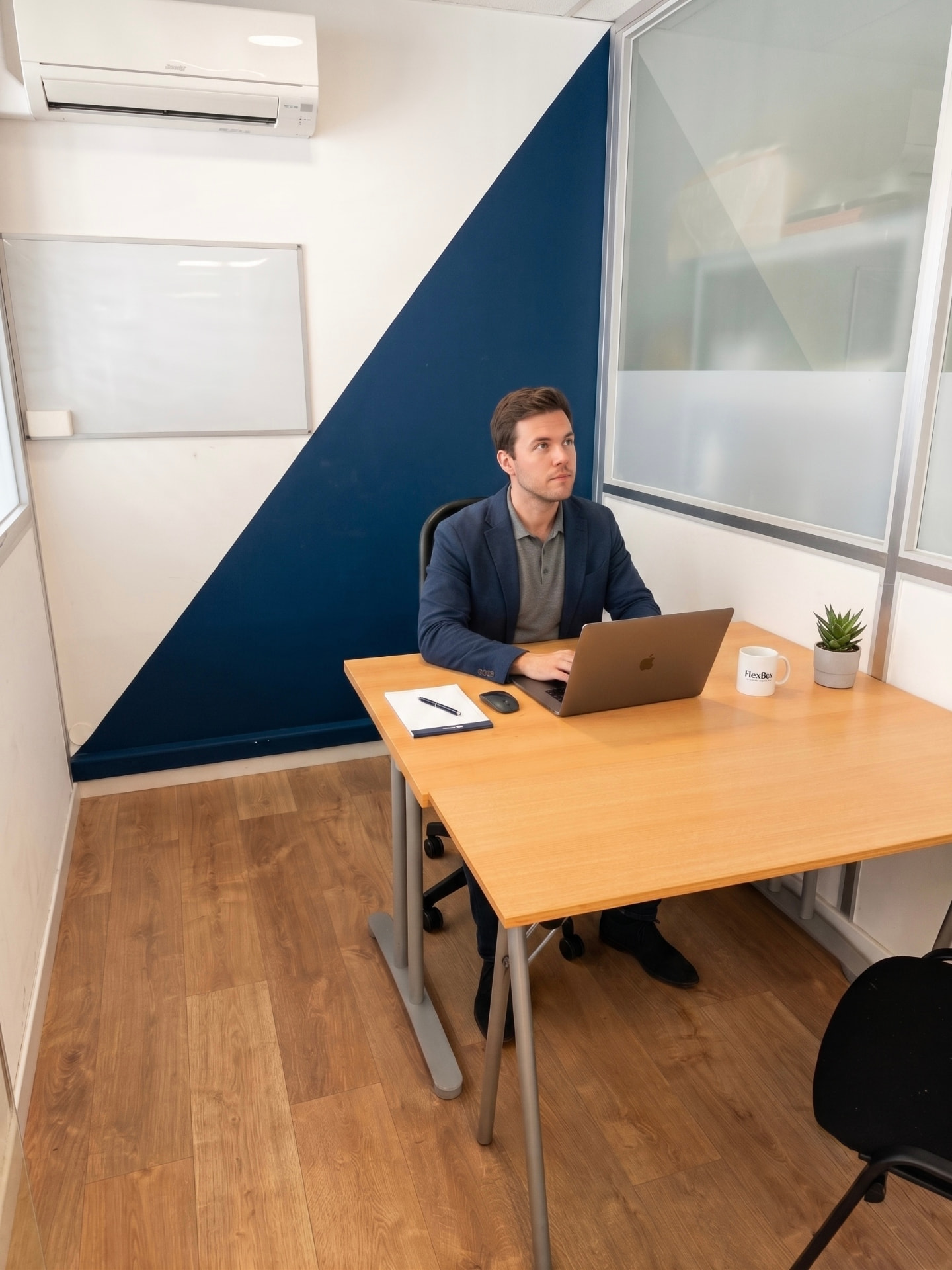 Bureau individuel fermé avec mur bleu profond et grande table de travail
